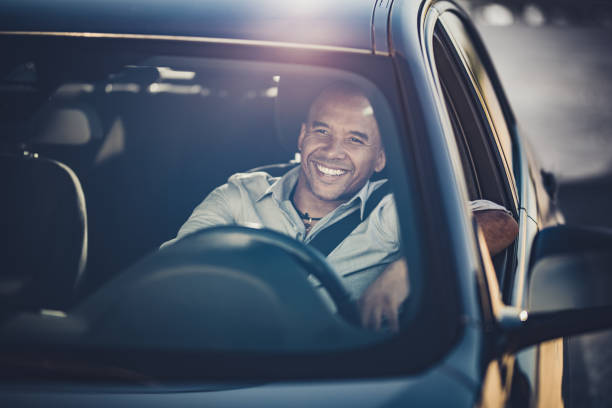 Happy black businessman enjoying while driving a car.