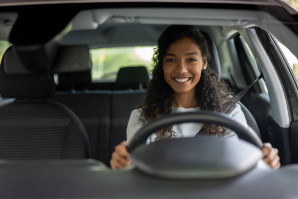 Portrait of a happy black woman looking very happy driving a car and smiling ??? lifestyle concepts